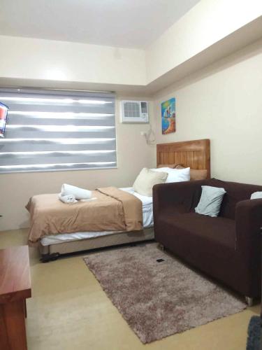 a living room with a couch and a bed at 324 Tower 1 Avida Iloilo Pool View Comfy Cozy Central in Iloilo City
