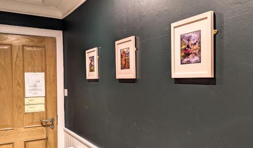 a hallway with three pictures on the wall at Falls of Lora Hotel in Oban