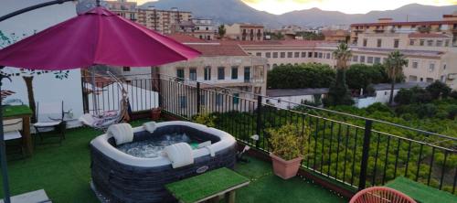 a patio with a hot tub on a balcony with an umbrella at I Sollazzi in Palermo