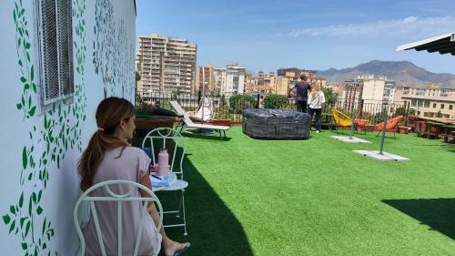 a woman sitting on the roof of a building at I Sollazzi in Palermo
