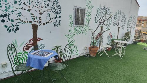 a patio with a table and chairs with trees painted on the wall at I Sollazzi in Palermo