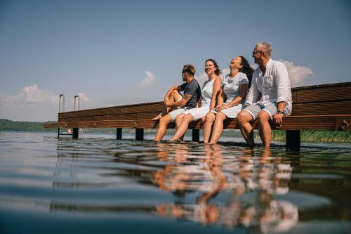 a group of people sitting on a bench in the water at Insel der Sinne in Görlitz