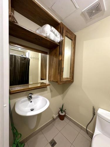 イロイロにあるTOWER 3 421 POOL VIEWの洗面台、鏡、トイレ付きのバスルーム