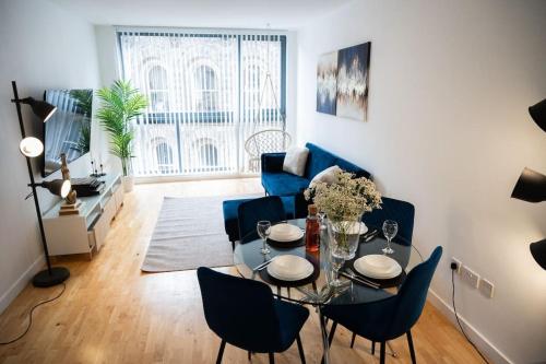 ein Wohnzimmer mit einem Tisch und blauen Stühlen in der Unterkunft Modern City Centre 2 Bed Apt in Leeds & Netflix & Hammock in Leeds