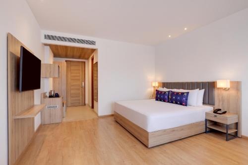 a hotel room with a bed and a tv at Keys Lite by Lemon Tree Hotels, Urban Square, Udaipur in Udaipur