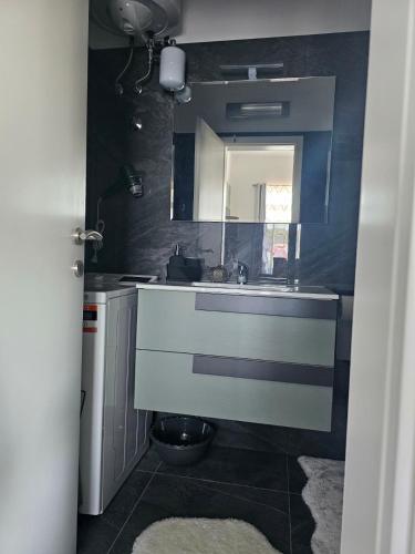 a bathroom with a sink and a mirror at Apartman Istria Green in Kaštel