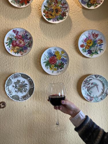a person holding a glass of wine next to plates on a table at Le Cedrus Hotel in Al Arz