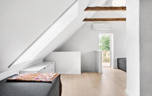 a room with white walls and a staircase with a couch at Cozy Home In Nørre Alslev With Wifi in Nørre Alslev