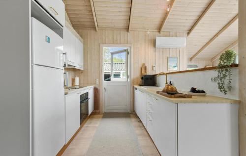 a kitchen with white cabinets and a white refrigerator at 3 Bedroom Gorgeous Home In Ebeltoft in Ebeltoft