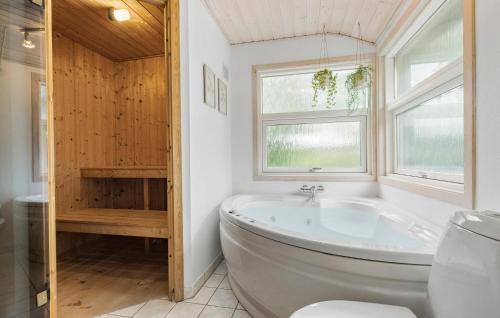 a bathroom with a large tub and a window at 3 Bedroom Gorgeous Home In Ebeltoft in Ebeltoft