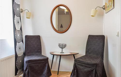 a room with two chairs and a table and a mirror at 3 Bedroom Beautiful Home In Blankaholm in Blankaholm