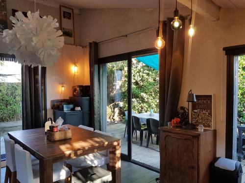 une salle à manger avec une table en bois et une salle à manger dans l'établissement Loft atypique en bord de plage, à Capbreton