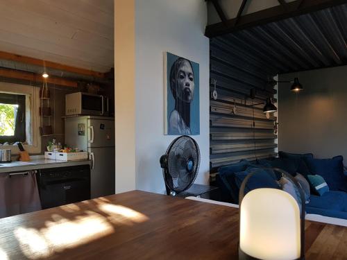 Il comprend une cuisine et un salon avec un canapé bleu. dans l'établissement Loft atypique en bord de plage, à Capbreton