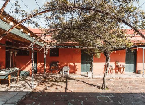 a red building with a tree in front of it at Estancia La violeta in Chajarí