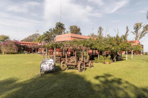 an old tractor in a field in front of a building at Estancia La violeta in Chajarí
