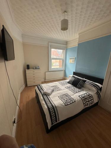 a bedroom with a large bed with a blue wall at Dreamwell Flats in London