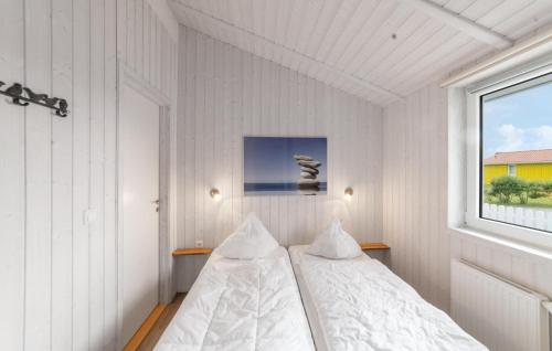 a white bedroom with a bed and a window at Friedrichskoog-Deichblick 4 in Friedrichskoog
