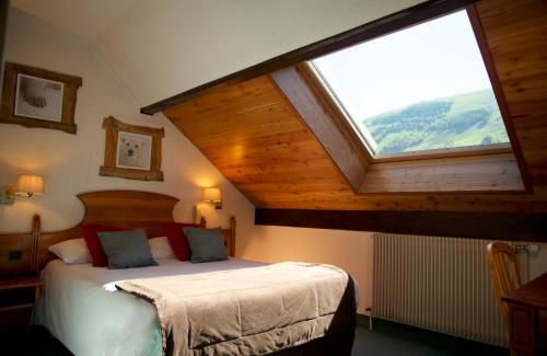 a bedroom with a bed with a large window at Hôtel Serre Palas in Les Deux Alpes