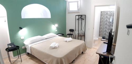 une chambre avec un lit avec deux serviettes dessus dans l'établissement Casa Ribes Rooms, l'angolo tranquillo alle porte della città, à Olbia