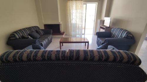 a living room with two couches and a coffee table at Angela's Apartment with beautiful balcony view in Agios Konstantinos Fthiotida