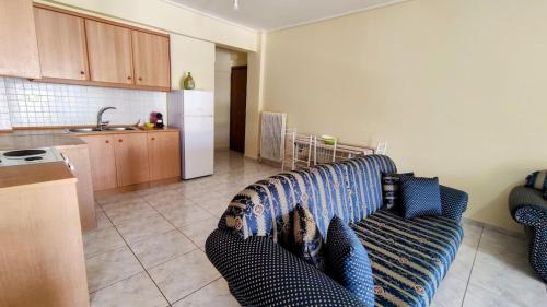 a living room with a couch and a kitchen at Angela's Apartment with beautiful balcony view in Agios Konstantinos Fthiotida
