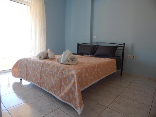 a bedroom with a bed with two stuffed animals on it at Angela's Apartment with beautiful balcony view in Agios Konstantinos Fthiotida
