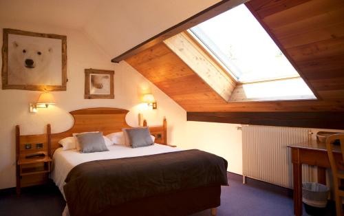 a bedroom with a large bed with a skylight at Hôtel Serre Palas in Les Deux Alpes