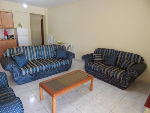a living room with two couches and a coffee table at Angela's Apartment with beautiful balcony view in Agios Konstantinos Fthiotida