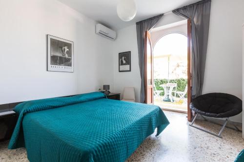 Schlafzimmer mit einem Bett mit blauer Tagesdecke in der Unterkunft Villa Edera by BarbarHouse in Marina di Lizzano