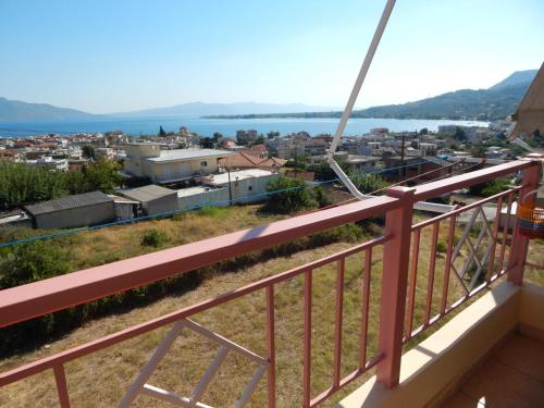 a balcony with a view of a city and the water at Angela's Apartment with beautiful balcony view in Agios Konstantinos Fthiotida