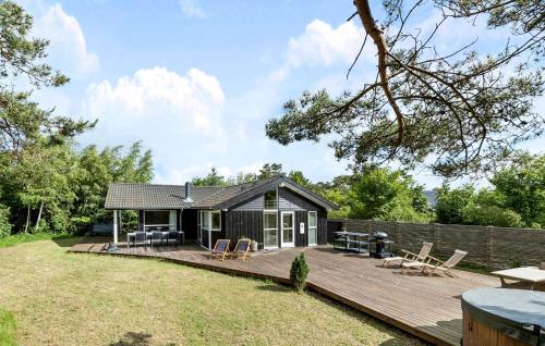 a small cabin with a wooden deck in the yard at Stunning Home In Gilleleje With Sauna in Gilleleje