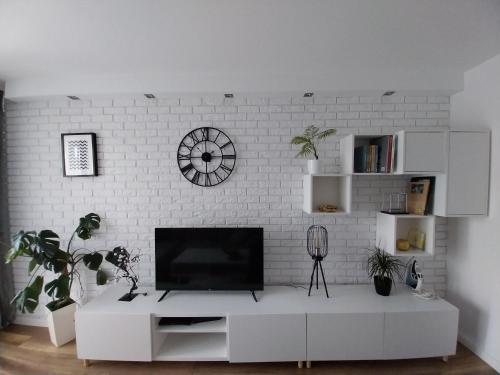 a living room with a tv on a white brick wall at Apartament na Sadowej in Sanok