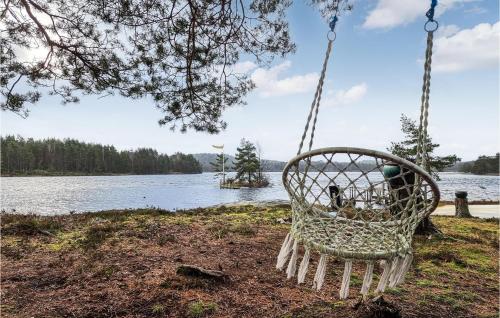 a swinging chair next to a lake at Nice Home In Nol With House Sea View in Nol