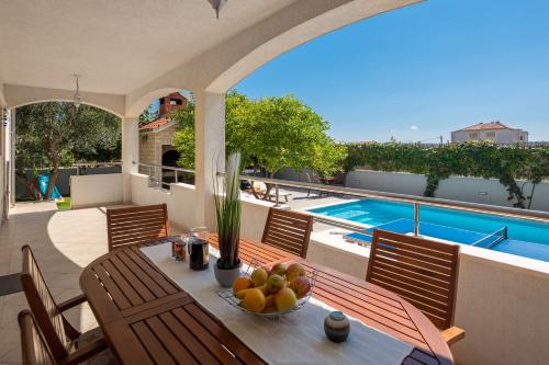ein Tisch mit einer Obstschale darauf auf einer Terrasse in der Unterkunft Sunshine Holiday Home in Kaštela