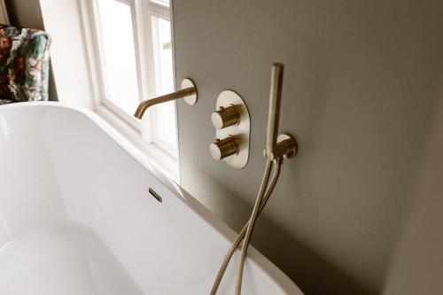 a bathroom with a bath tub and a window at Hotel Restaurant Belvédère in Schoonhoven
