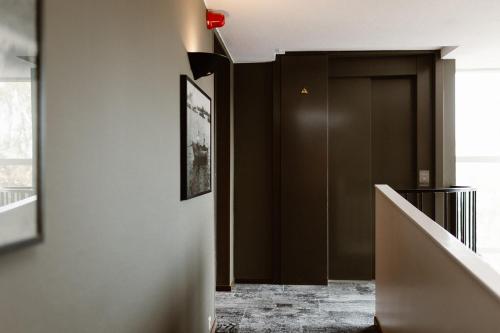 a hallway with a dark brown door and a staircase at Hotel Restaurant Belvédère in Schoonhoven