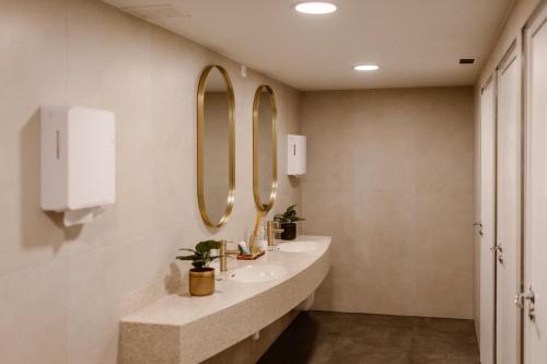 a bathroom with two sinks and two mirrors at Hotel Restaurant Belvédère in Schoonhoven