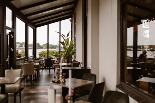 a restaurant with tables and chairs and a large window at Hotel Restaurant Belvédère in Schoonhoven