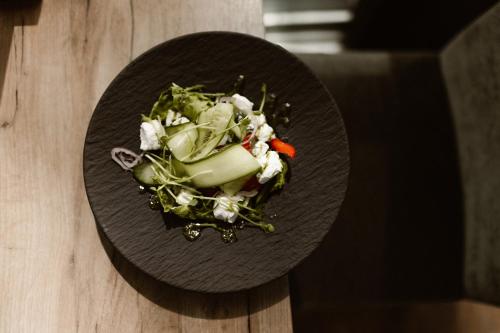 a black plate with a salad on a table at Hotel Restaurant Belvédère in Schoonhoven