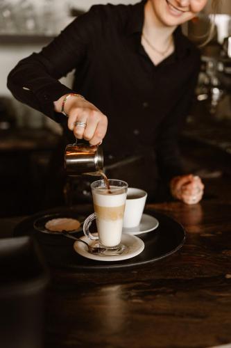a woman pouring coffee into a cup on a table at Hotel Restaurant Belvédère in Schoonhoven