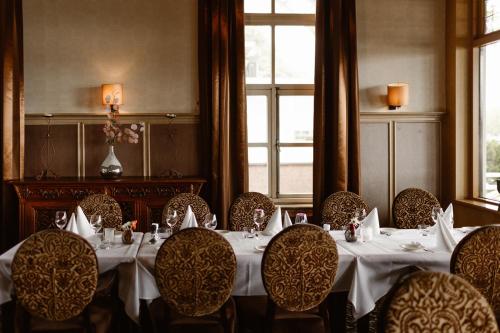 a dining room with a table and chairs and a window at Hotel Restaurant Belvédère in Schoonhoven
