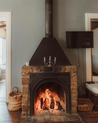 a stone fireplace in a living room with a tv at Estancia La violeta in Chajarí