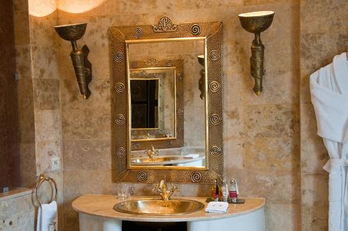a bathroom with a gold mirror and a sink at Le Temple Des Arts in Ouarzazate
