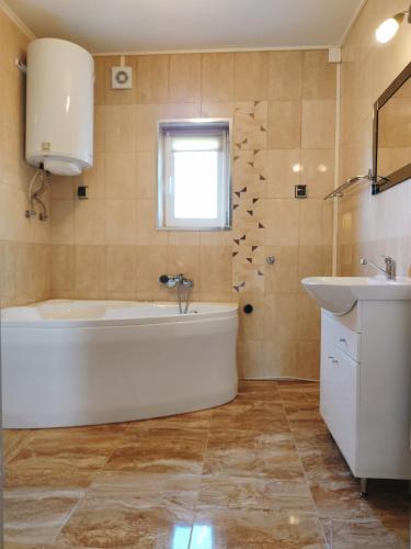 a bathroom with a tub and a sink at Ośrodek Wczasowy U Góralki in Murzasichle