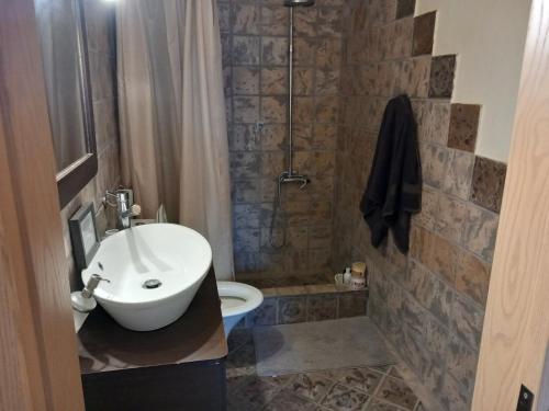 Un baño con lavabo, inodoro y ducha. en Mary House, en Pefkali