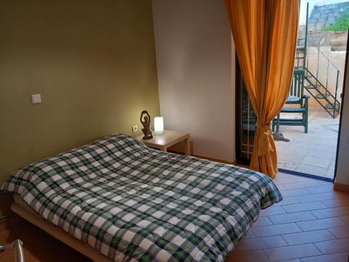 Un dormitorio con una cama y vista a un balcón. en Mary House, en Pefkali