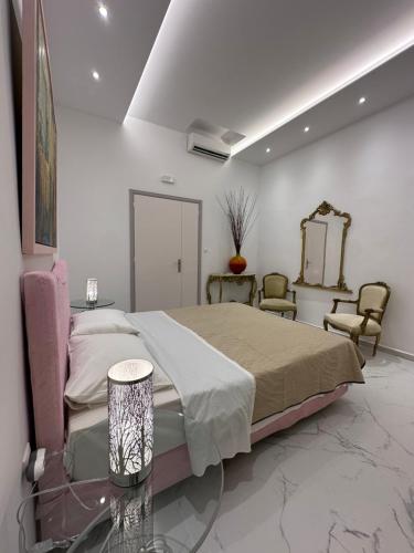 a bedroom with a bed and a mirror and chairs at City center beach house in Rhodes Town