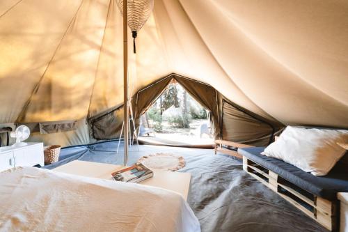 une tente avec un lit et un canapé dans l'établissement Saint Paul le Marseillais Tentes Equippees Hébergements Insolites Lodges, à Mèze