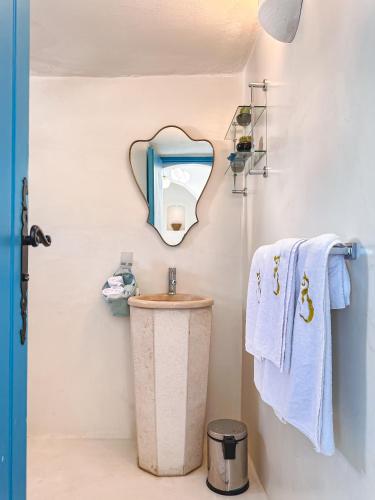 a bathroom with a sink and a mirror and towels at Dar Fen Luxery House in Houmt Souk