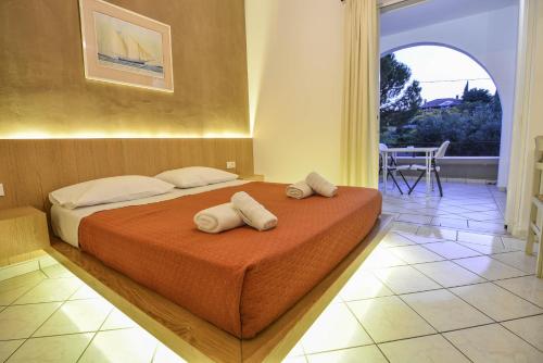 a bedroom with a bed with two towels on it at Epavlis Beach Resort in Porto Heli